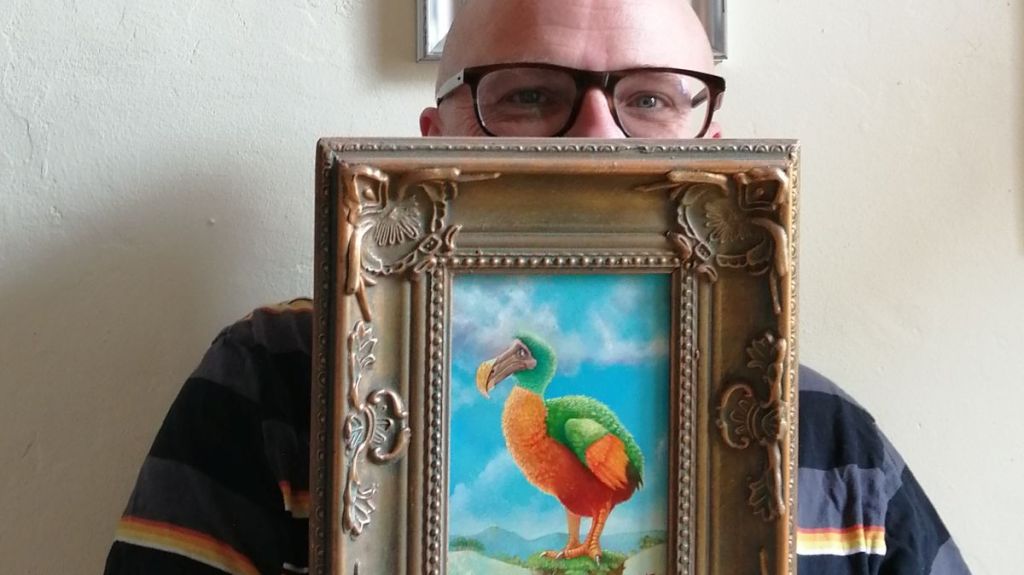 Andrew Tong holding a painting of a dodo waiting for contact